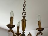 a chandelier with three lights hanging from it ' s ceiling