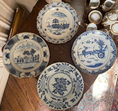 several blue and white plates and bowls on a wooden table