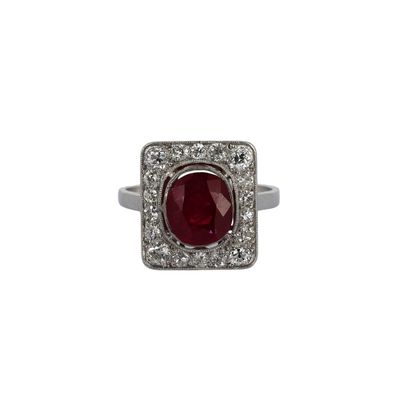 gros plan d'une bague avec une pierre rouge entourée de diamants blancs