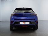 the rear end of a blue car in a white room