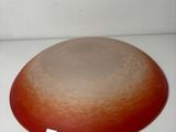 a red and white plate sitting on a white surface