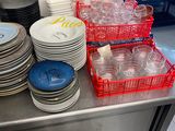 many plates and cups on the counter in the kitchen