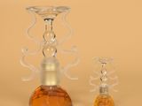 two glass candlesticks sitting next to each other on a table