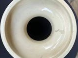 a white vase sitting on a table with a black base
