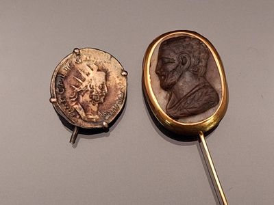 two gold and silver items on display on a table