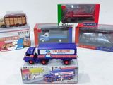 quatre camions miniatures posés sur une surface blanche