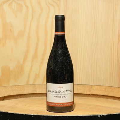 a bottle of wine sitting on top of a barrel