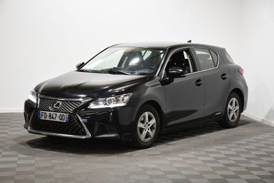 La voiture noire est garée dans une pièce dont le sol est en damier.