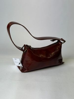 brown leather handbag on a white surface with a white background