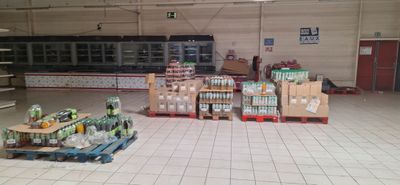 de nombreuses caisses de sodas et de canettes par terre dans le magasin