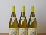 trois bouteilles de vin posées sur une table en bois