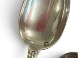 two spoons that are next to each other on a table