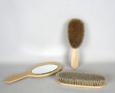 une brosse en bois et un miroir posés sur une table