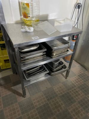a metal table with a bunch of plates and pans on it