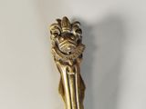 a gold spoon with a lion head on top of it