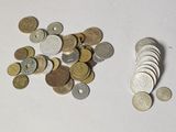 une pile de pièces de monnaie posée sur une table à côté d'une pile de pièces de monnaie