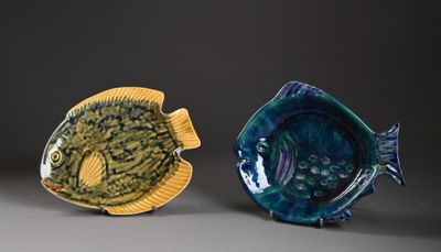 deux poissons en céramique posés l'un à côté de l'autre sur une table