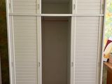 a closet in the corner of a room with a wallpapered wall