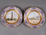 two plates with a picture of a monument and a building