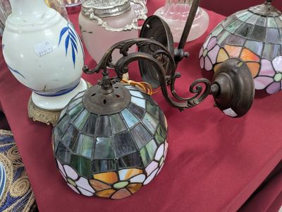 trois lampes posées sur une table recouverte d'une nappe rouge