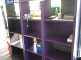 une bibliothèque violette dans un coin de la pièce