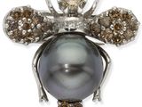 un gros plan sur une broche en forme d'abeille, composée d'une perle noire et de diamants