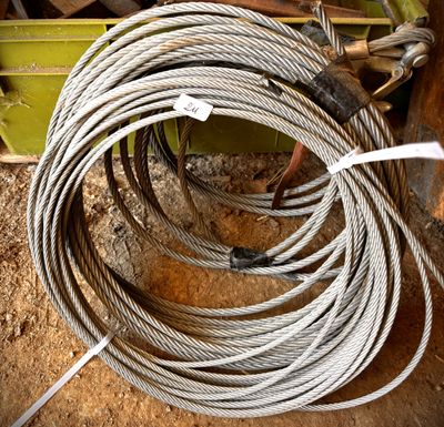 une corde posée par terre à côté d'un tas de bois