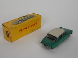 a green toy car and a box on a white surface