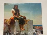 a book with a painting of a woman sitting on a wall