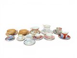 many cups and saucers that are sitting on a table