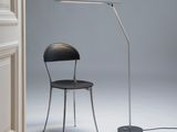 the chair is next to the floor lamp in the corner of the room