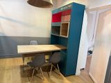 a table and chairs in a room with a blue bookcase