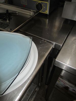 un saladier bleu posé sur un plan de travail, à côté d'une cuisinière