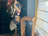 une pile de vêtements suspendus à un portant dans un coin de la pièce