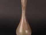 a brown vase that is sitting on a black surface