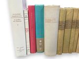 many books that are lined up together on a shelf