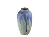 un vase bleu et blanc posé sur une surface blanche