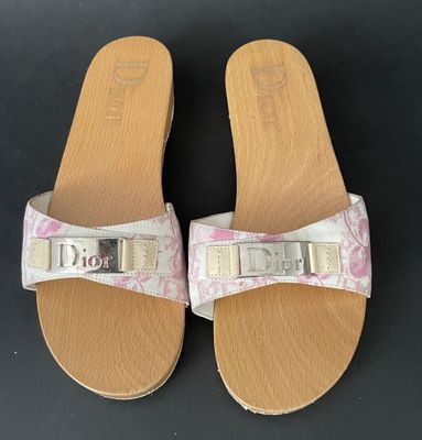 a pair of white sandals with pink flowers on them