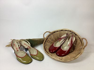 two pairs of red and green shoes and a basket with a broom