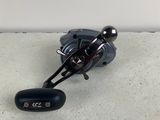 a close up of a fishing reel on a concrete surface