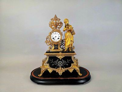 Pendule en régule doré et marbre noir à décor d'une femme à …