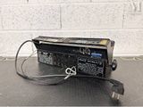a black power supply sitting on a table with a white brick wall in the background