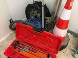 a red tool box with tools in it next to a traffic cone
