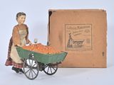 a figurine of a woman pushing a cart of carrots
