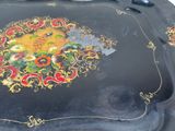 a black tray with a gold and red design on it