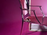 a pink room with a chair and a table in it