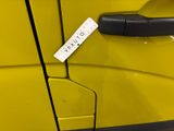 a yellow car with a tag on the door handle