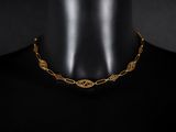 gros plan d'un collier en or sur un mannequin