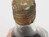 a close up of a bottle of liquid on a white surface