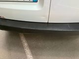 the rear end of a white car parked in a parking lot
